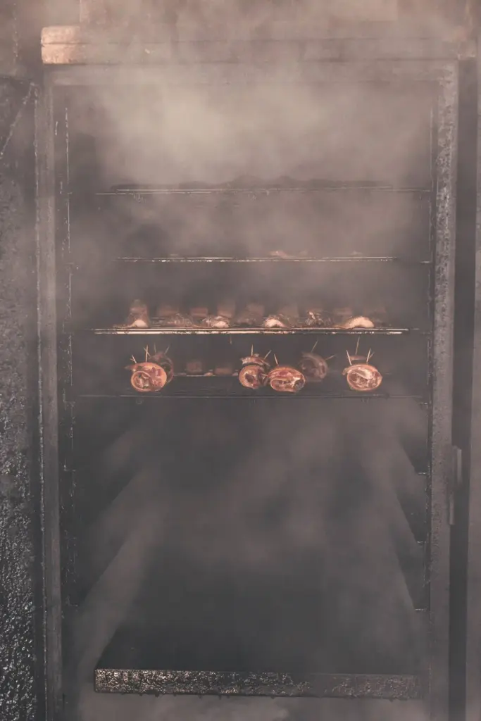 Frischer Fisch in Brandenburg und Sachsen im geöffneten dampfenden Räucherofen, frisch nach dem Räuchern: Frischer Lachs im geöffneten dampfenden Räucherofen, frisch nach dem Räuchern